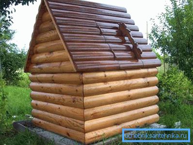 Dům a dobře uvnitř. Kombinace kovu (střecha z vlnité lepenky) a dřeva (stěny zaoblených kulatiny)