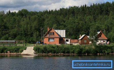 Fotografie venkovské chalupy u řeky