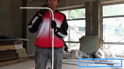 Na fotografii je zobrazena kovová plastová trubka ohnutá pod úhlem 90 stupňů.