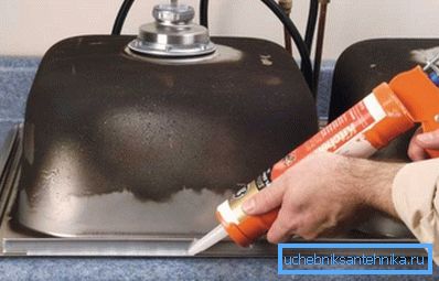 Použití silikonu na vnitřní straně kuchyňského dřezu z nerezové oceli před jeho instalací do pracovní desky Použití silikonu na vnitřní straně kuchyňského dřezu z nerezové oceli před jeho instalací do pracovní desky